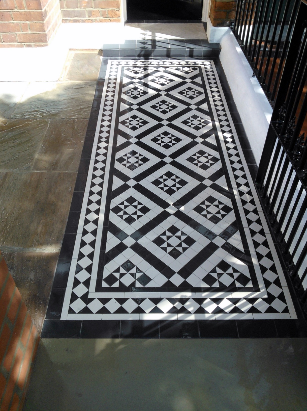 Black and white victorian mosaic tile path red brick garden wall